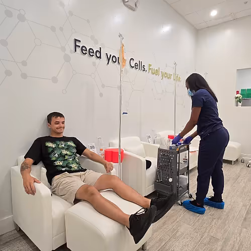 Client seated comfortably receiving IV therapy from a licensed nurse